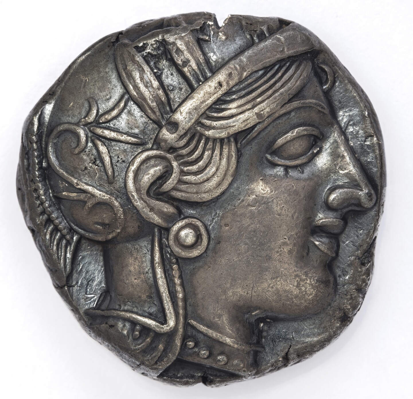 Antike griechische Silbermünze mit Profilbild der Athena mit Helm