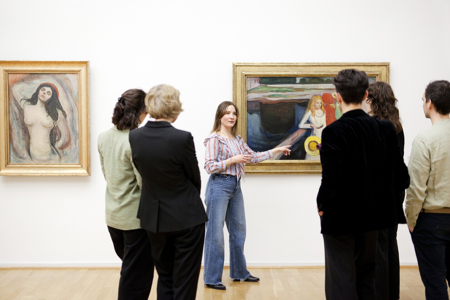 Museumsbesucher betrachten Kunstwerke an einer weißen Galeriewand