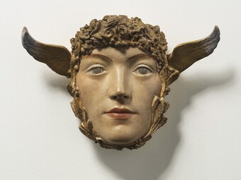 Blumenumringte Maske mit Flügeln auf weißem Hintergrund