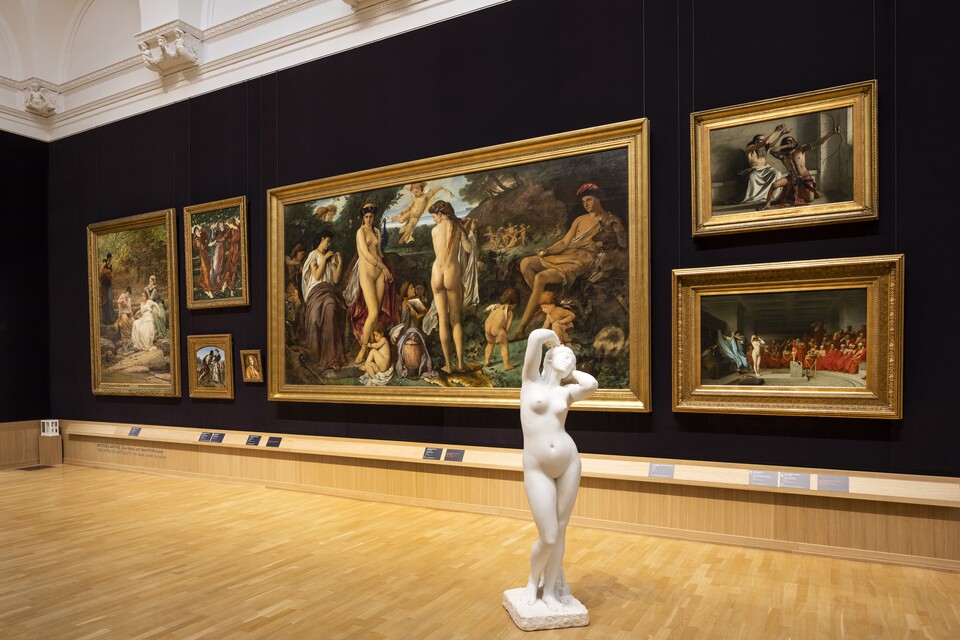 Gemäldegalerie mit großformatigen, gerahmten Gemälden an dunkler Wand mit einer Skulptur davor