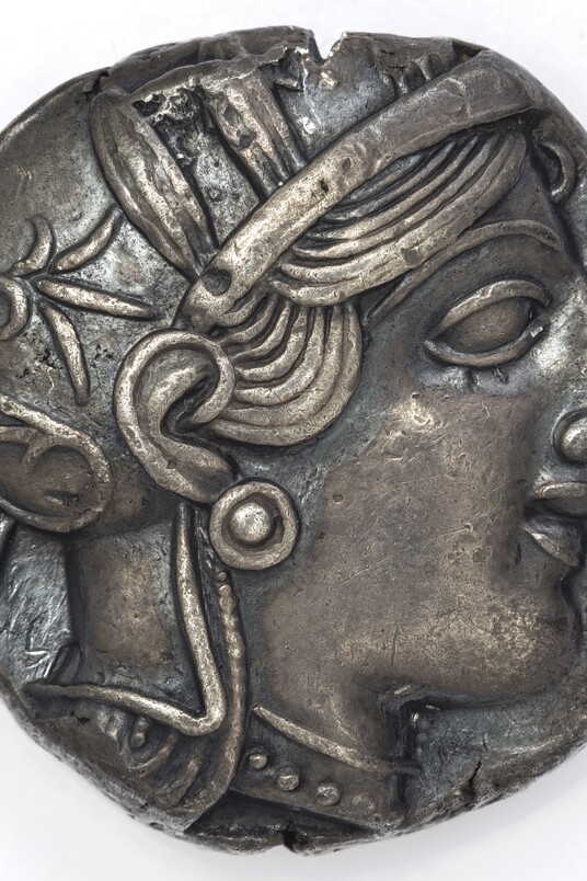 Antike griechische Silbermünze mit Profilbild der Athena mit Helm