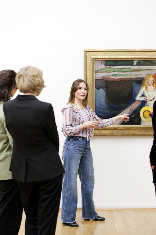 Museumsbesucher betrachten Kunstwerke an einer weißen Galeriewand