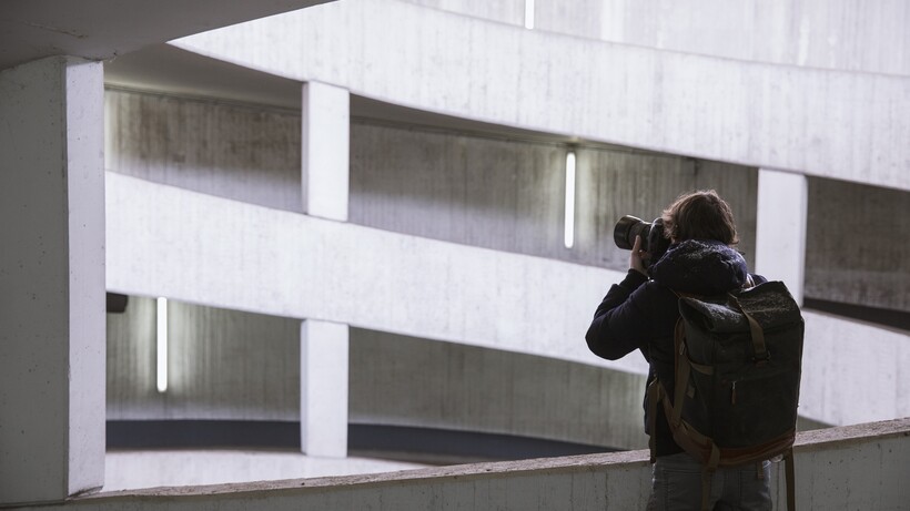 Person fotografiert moderne Architektur mit geometrischen weißen Betonformen